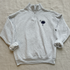 A light heather gray quarter-zip sweatshirt featuring the navy blue South Carolina Palmet and Spear logo with a crescent moon on the left chest, displayed flat against a white background.