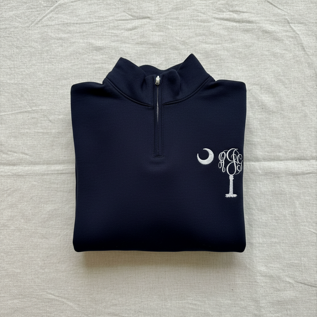 A navy blue quarter-zip sweatshirt with a white embroidered Southern cross tree and crescent moon logo on the left chest, displayed flat against a white background.