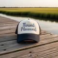 A two-tone trucker hat with a cream front panel and dark navy brim and mesh back, featuring the words 'Mount Pleasant' embroidered in a dotted script across the front.